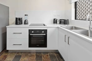 Een moderne keuken met een Bosch oven, een koffiezetapparaat en een broodrooster.