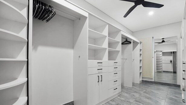 A walk-in closet with open shelving, drawers, and hanging space.