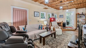 A living room with a sofa, a coffee table, a TV, and a bookshelf.