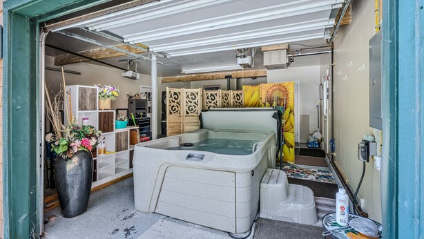 A spa room with a hot tub, wooden decor, and a projector on the ceiling.