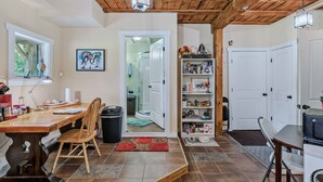 A home interior with a dining area, a bookshelf, and a door leading to another room.