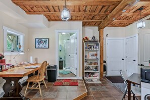 Interior de una vivienda con comedor, una estantería y una puerta que da a otra habitación.
