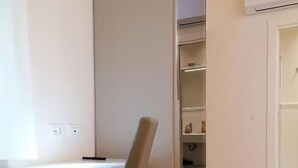 Una habitación con escritorio, silla y estantería.