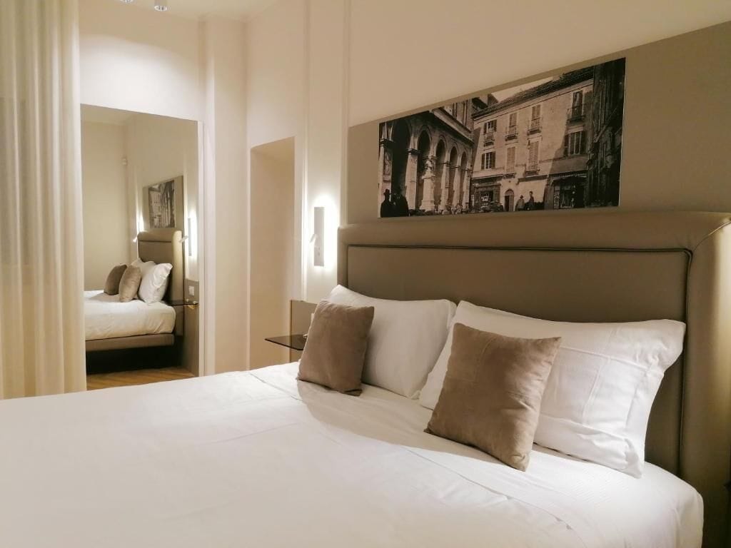 Une chambre d’hôtel avec un lit, une table de chevet et un tableau accroché au mur.
