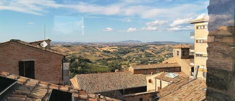 Vista de un pueblo con edificios de tejados de teja y cielo despejado.