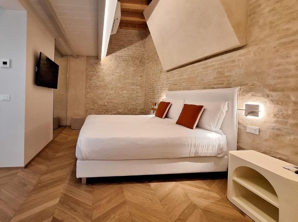 Una camera da letto con un letto, una televisione e un lampadario a parete.