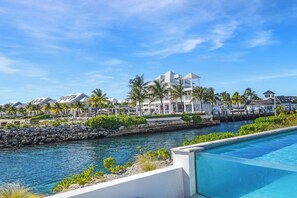 A resort with a pool, a waterway, and buildings with a white facade. - Palm Cay - 3BR Beachfront Penthouse + Private Pool (Nassau)