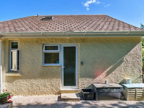 A single-story building with a tiled roof, a front door, and a small window. - Apartment With Jacuzzi Bath (Torpoint)