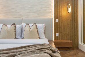 A hotel room with a bed, a nightstand, a wall-mounted light, and a wooden panel wall. - Sophisticated High-Floor 1BR with Balcony Featuring Partial Sea Views (Dubai)