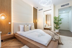 Un dormitorio moderno con cama empotrada, mesitas de noche, un espejo y una planta en maceta.