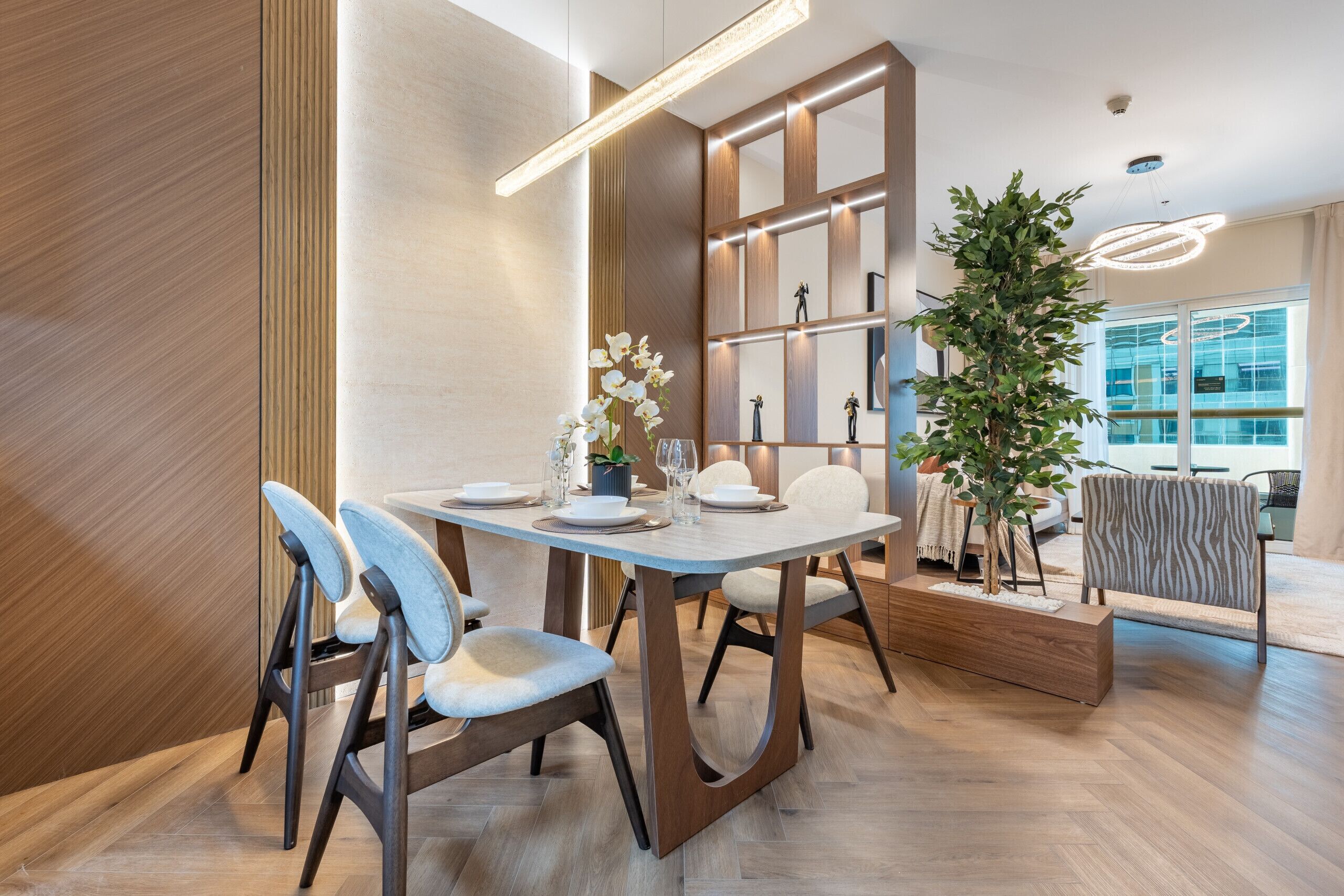 A modern dining area with a wooden table, chairs, and a decorative plant.
