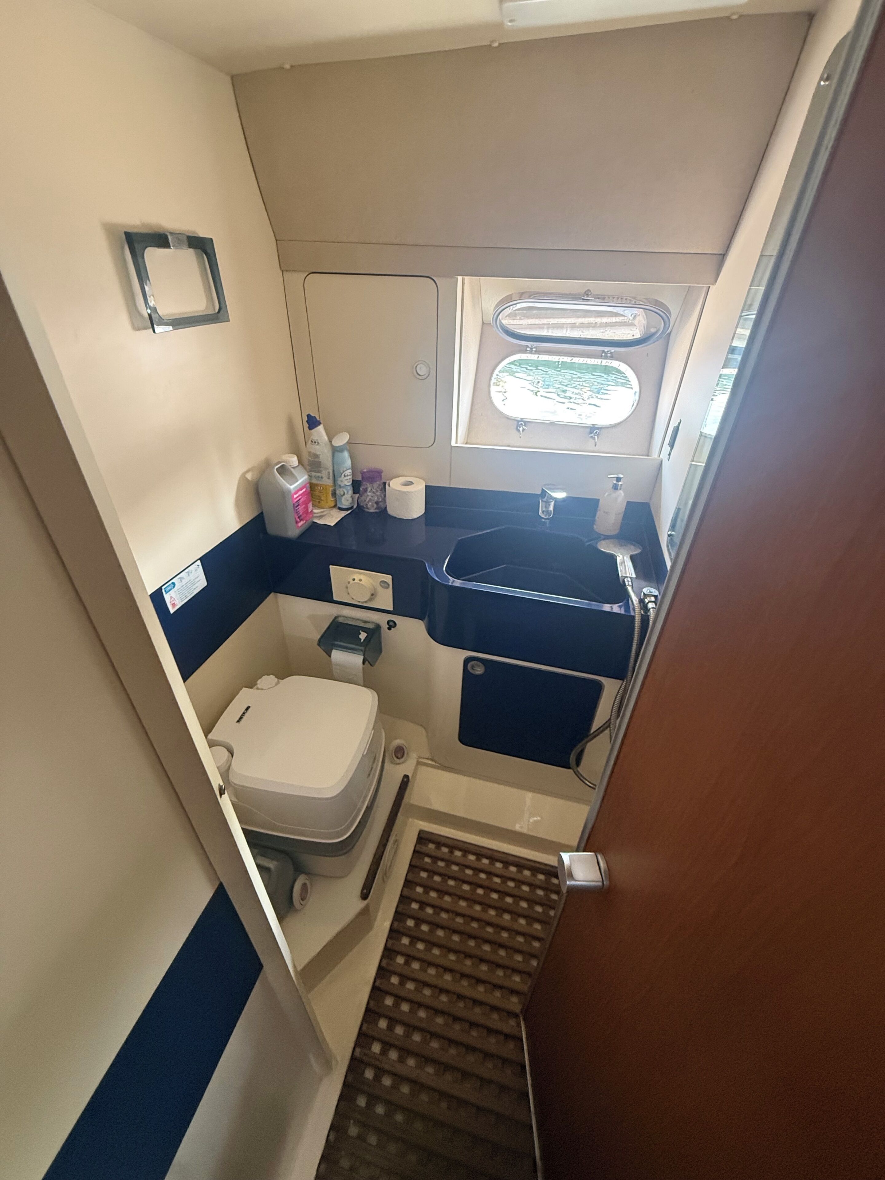 A compact bathroom with a toilet, sink, and shower area.