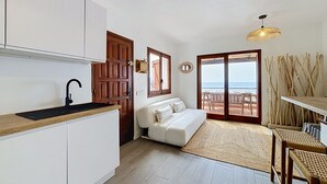 A compact living space with a kitchenette, a sofa, a dining area, and a view of the sea. - BRAMER 36 Rosas / Roses - INTERimmo (Rosas / Roses)