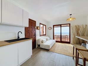 A compact living space with a kitchenette, a sofa, a dining area, and a view of the sea. - BRAMER 36 Rosas / Roses - INTERimmo (Rosas / Roses)