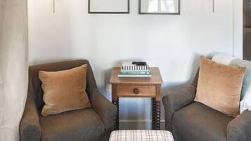 A room with two sofas, a small table with a book, and framed pictures on the wall.