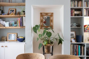 A room with a bookshelf, a framed mirror, and a potted plant. - Eclectic Character Home | Garden & City Location - Pass the Keys (Brighton)