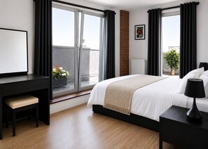 A modern bedroom with a bed, bedside table, desk, chair, and a window with curtains. - River Views | 2BR 2BA | Roof Terrace + Parking - Pass the Keys (London)
