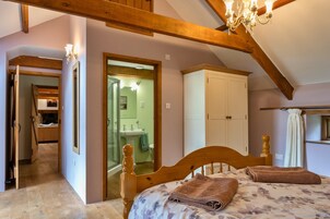 A bedroom with a wooden bed, a bathroom with a sink, and a mirror.