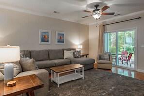 A living room with a sofa, coffee table, and a ceiling fan. - Willow Bend At Barefoot 1111 (North Myrtle Beach)