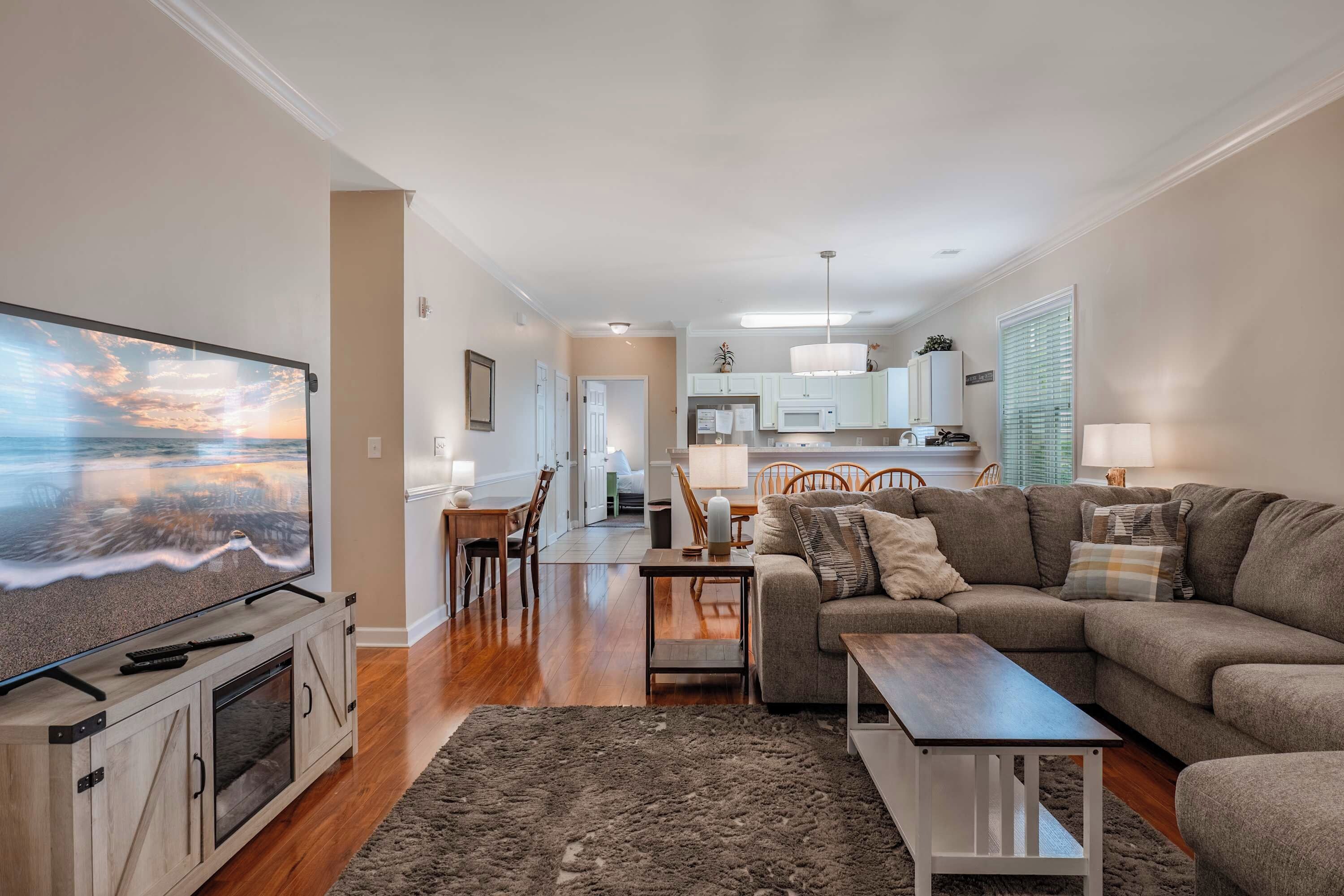 A living room with a television, a sofa, a coffee table, and a rug.
