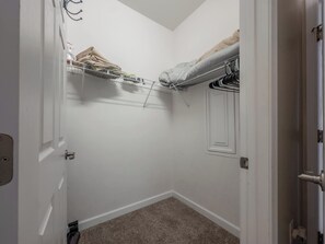 A small, narrow room with a closet containing hanging clothes and a folded blanket. - Willow Bend At Barefoot 1111 (North Myrtle Beach)