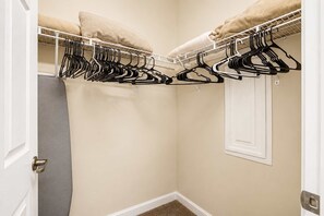 A walk-in closet with a white door, beige walls, and a white floor. - Willow Bend At Barefoot 1111 (North Myrtle Beach)
