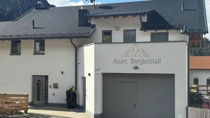 Ein Gebäude mit einem Schild, auf dem 'Apart Bergkristall' steht, und einer Garagentür.
