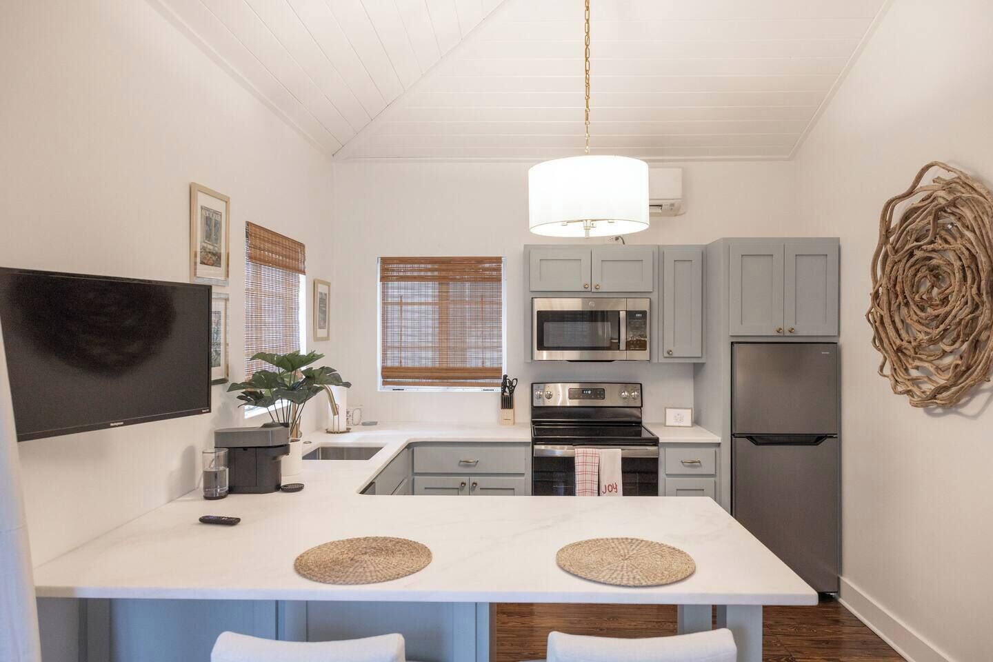 A compact kitchen with a central island, a microwave, oven, and refrigerator.