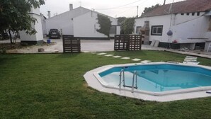 A swimming pool with a wooden deck and a metal ladder. - Green Palace-Guest House (Vale de Figueira)