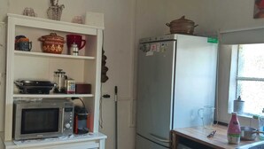A compact kitchen with a microwave, refrigerator, and washing machine. - Green Palace-Guest House (Vale de Figueira)