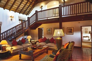 A spacious living area with a staircase, a sofa set, and a coffee table.