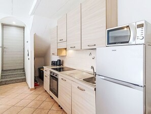 Eine kleine Küche mit Mikrowelle, Backofen und Spüle.