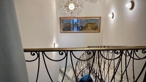 A staircase with ornate metal railings and wall-mounted decorative lights.