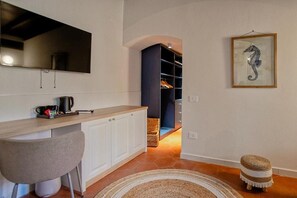 A modern kitchen with a wooden countertop, a chair, and a coffee maker.