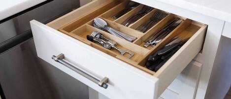 A kitchen drawer with utensils and cookware.