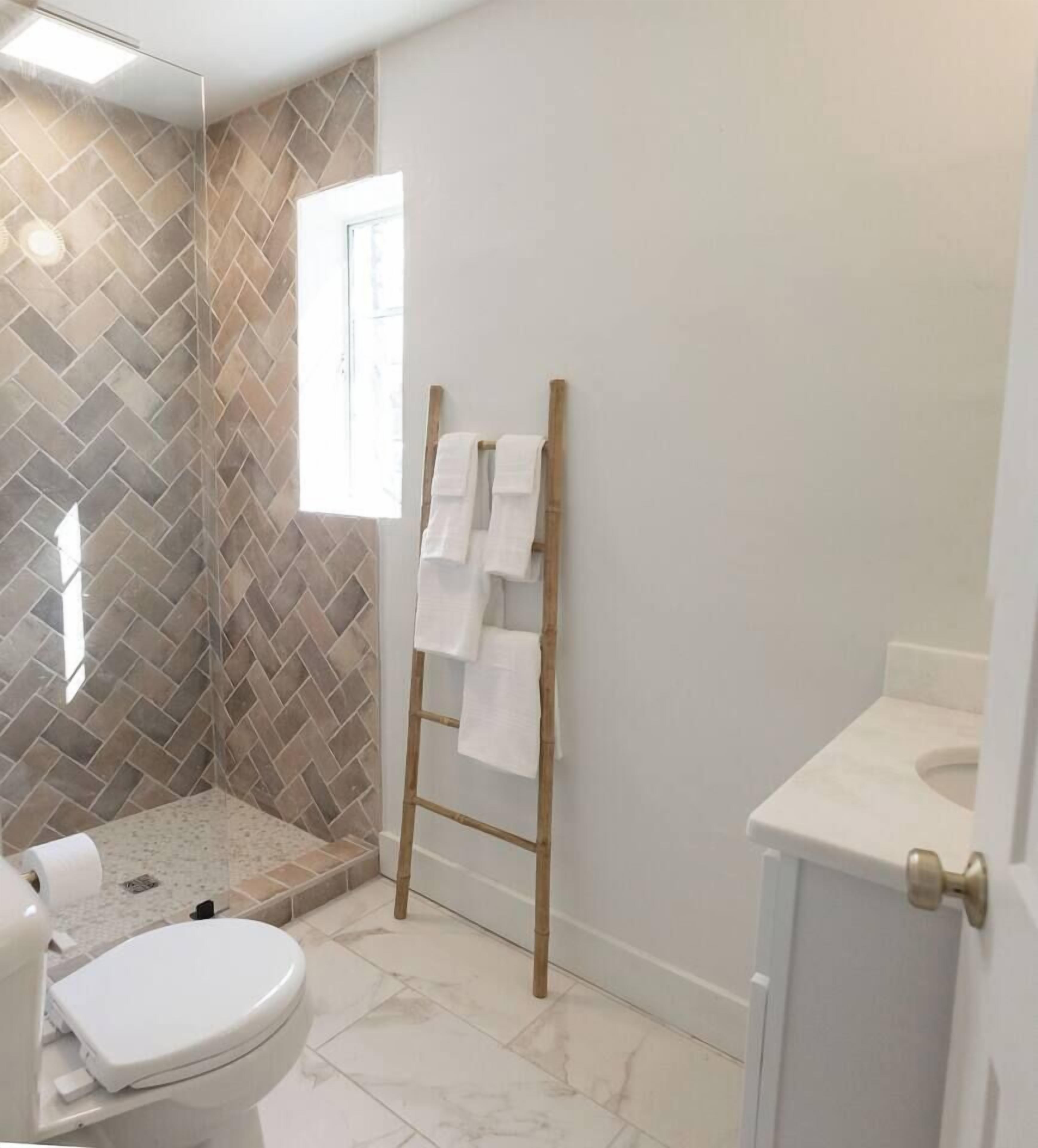A bathroom with a shower, toilet, and sink.