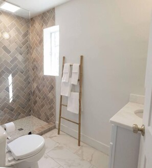 A bathroom with a shower, toilet, and sink.