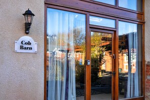 Ein Gebäudeeingang mit einem Schild, auf dem 'Cob Barn' steht, und einem Sicherheitstastenfeld an der Tür.