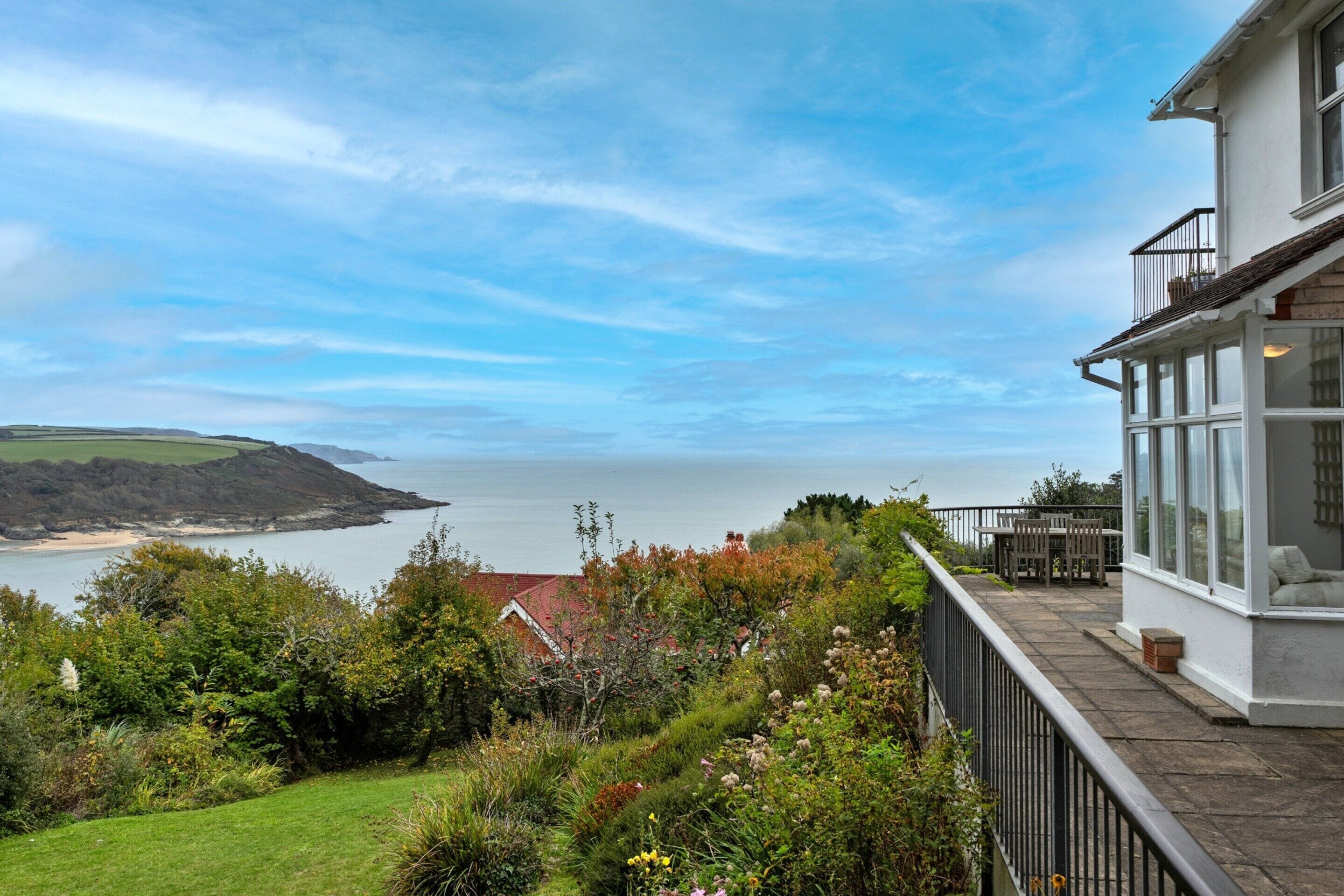 A coastal property with a view of the sea and hills.