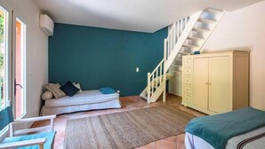 A room with a staircase, a sofa, a cabinet, and a bed. - Villa 'Maison Rouge - Esprit Du Sud' with Sea View, Private Pool and Wi-Fi (Sainte-Maxime)