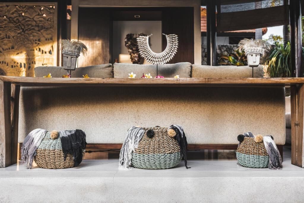 A room with a sofa, decorative items, and woven baskets.