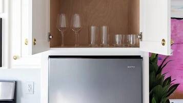 A kitchen with a built-in refrigerator and a cabinet with wine glasses.