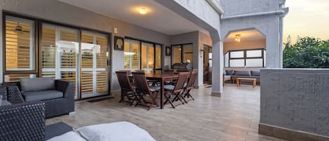 Une vaste terrasse extérieure comprenant un espace repas, des sièges et une vue sur le paysage environnant.