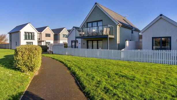 A residential area with multiple houses, a pathway, and a white picket fence. - Westward Ho Seaside Stay ( (Bideford)