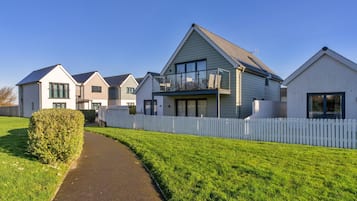 A residential area with multiple houses, a pathway, and a white picket fence.