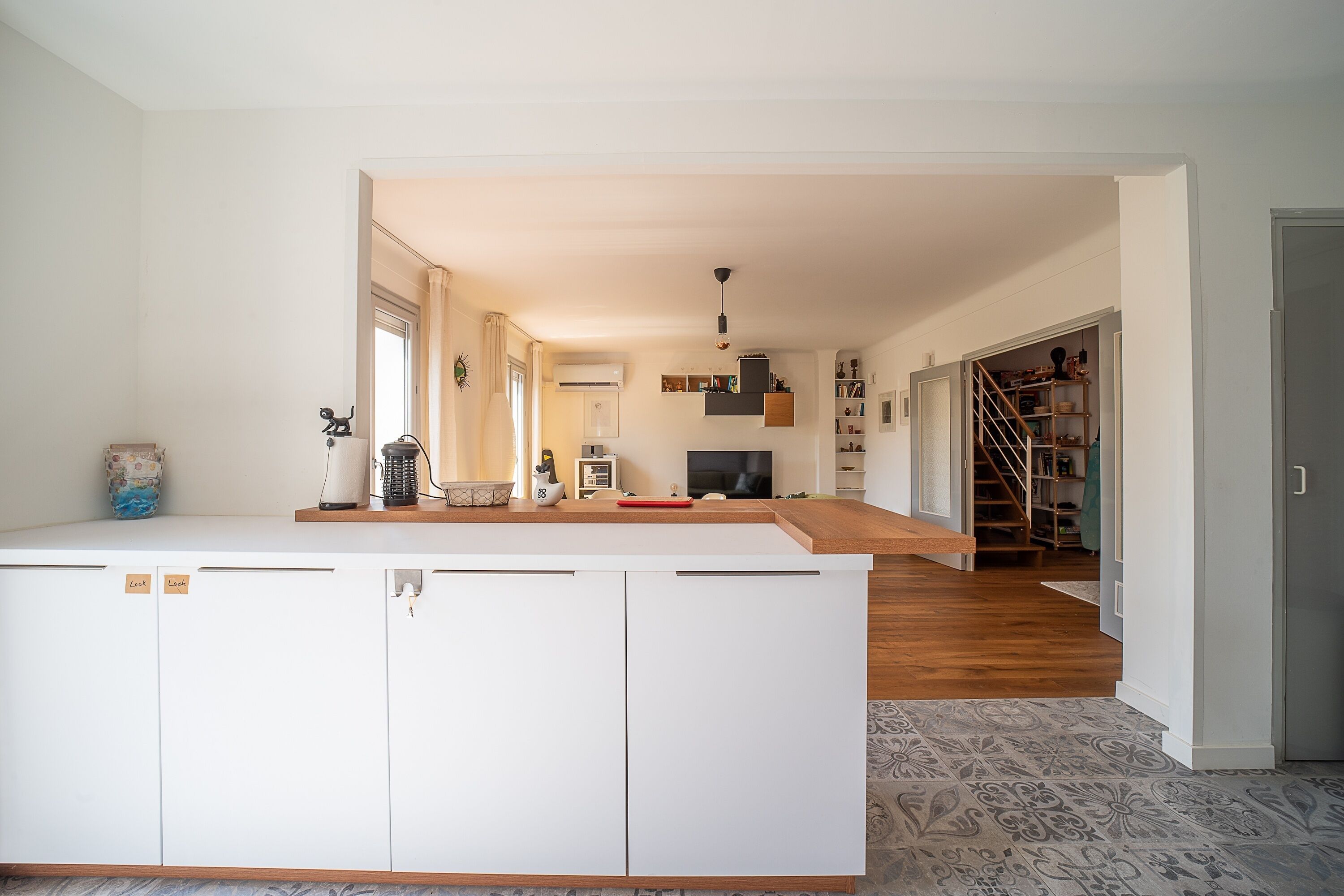 A spacious living area with a kitchen, a dining area, and a staircase leading to a loft.