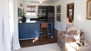 Un espacio habitable compacto con kitchenette, zona de comedor y área de descanso.