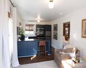 A compact living space with a kitchenette, a dining area, and a seating area.