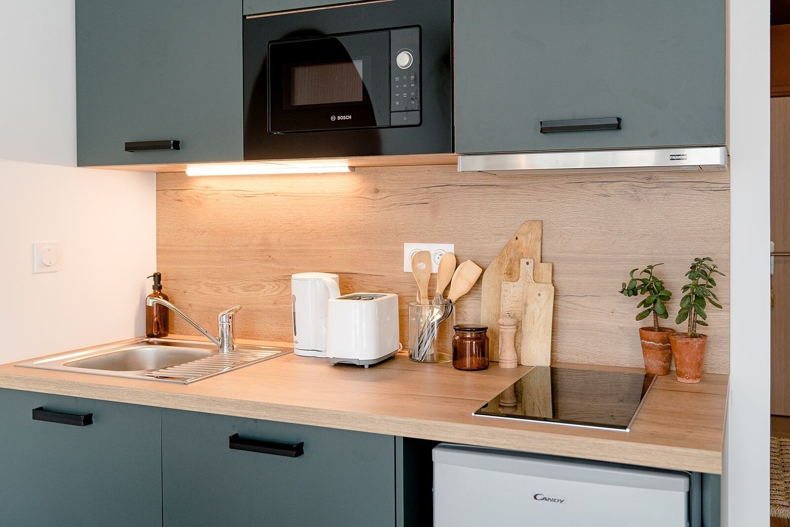 Een koffiezetapparaat/waterkoker, een koelkast, een oven, een vaatwasser