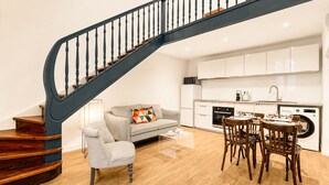 Ein modernes Apartment mit Wendeltreppe, Essbereich, Küche und Wohnzimmer.